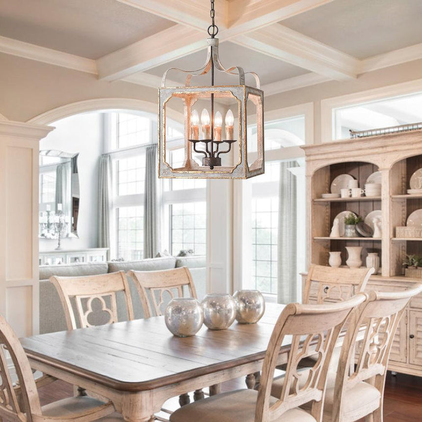 Lit above a pale dining table and chairs under a coffered ceiling with a dresser