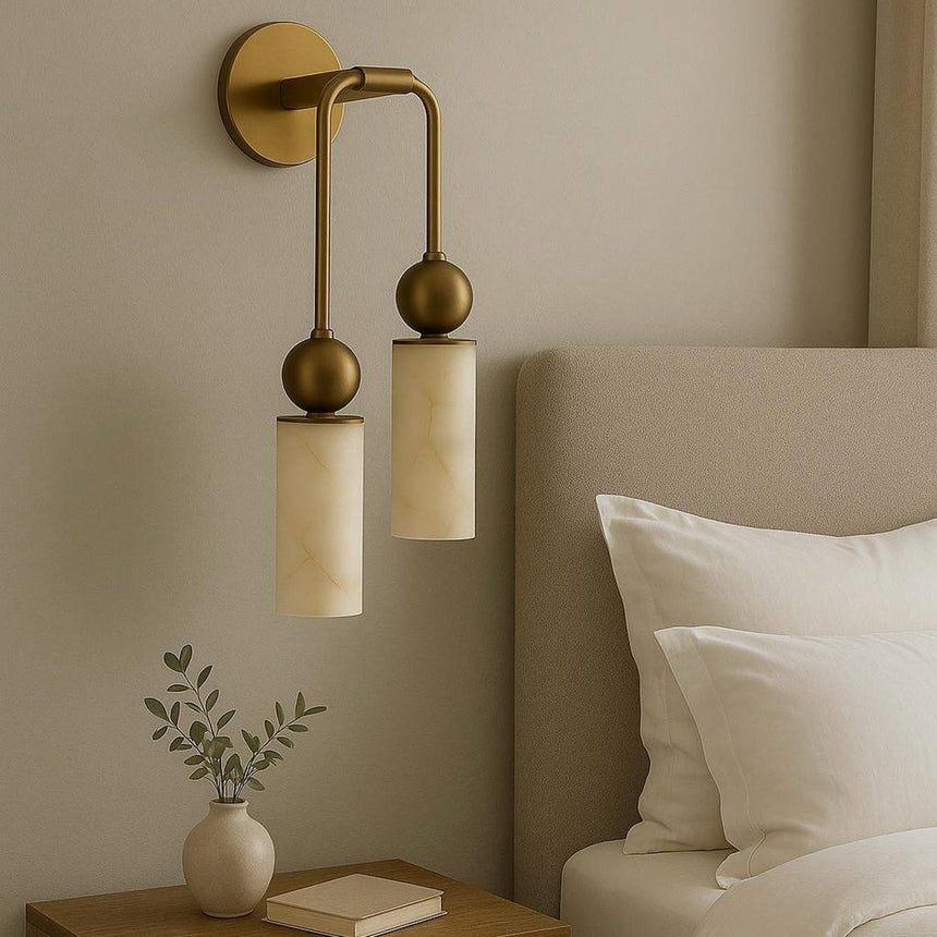 The light lit beside a bed with white pillows and a small nightstand