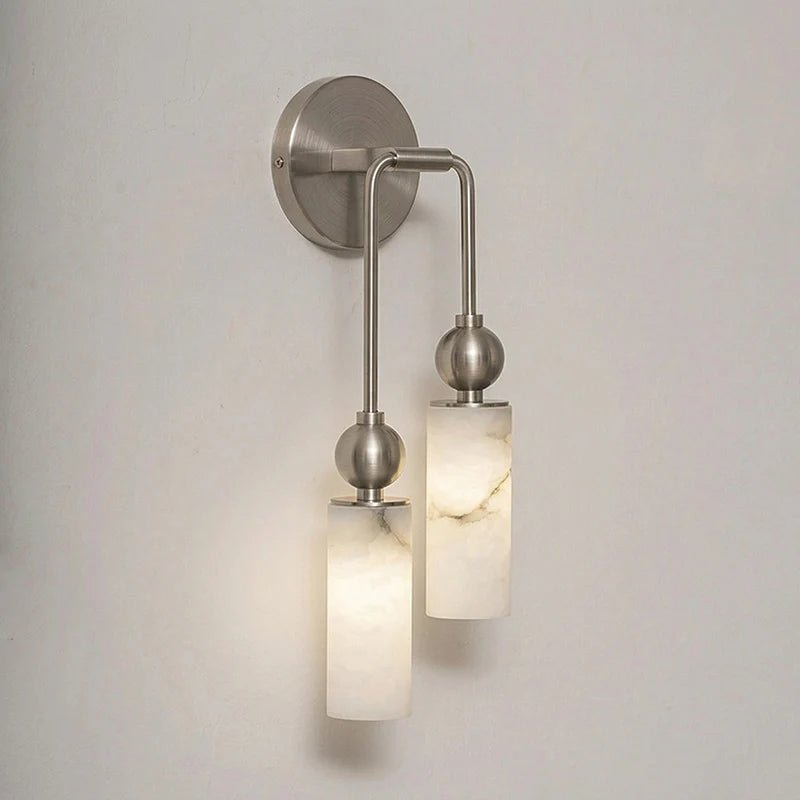 The nickel version with two lit stone cylinders on a plain wall