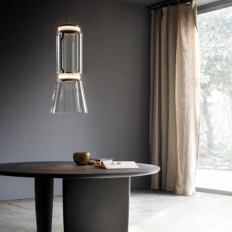 The stacked cylinder pendant lit beside a round table and a curtain