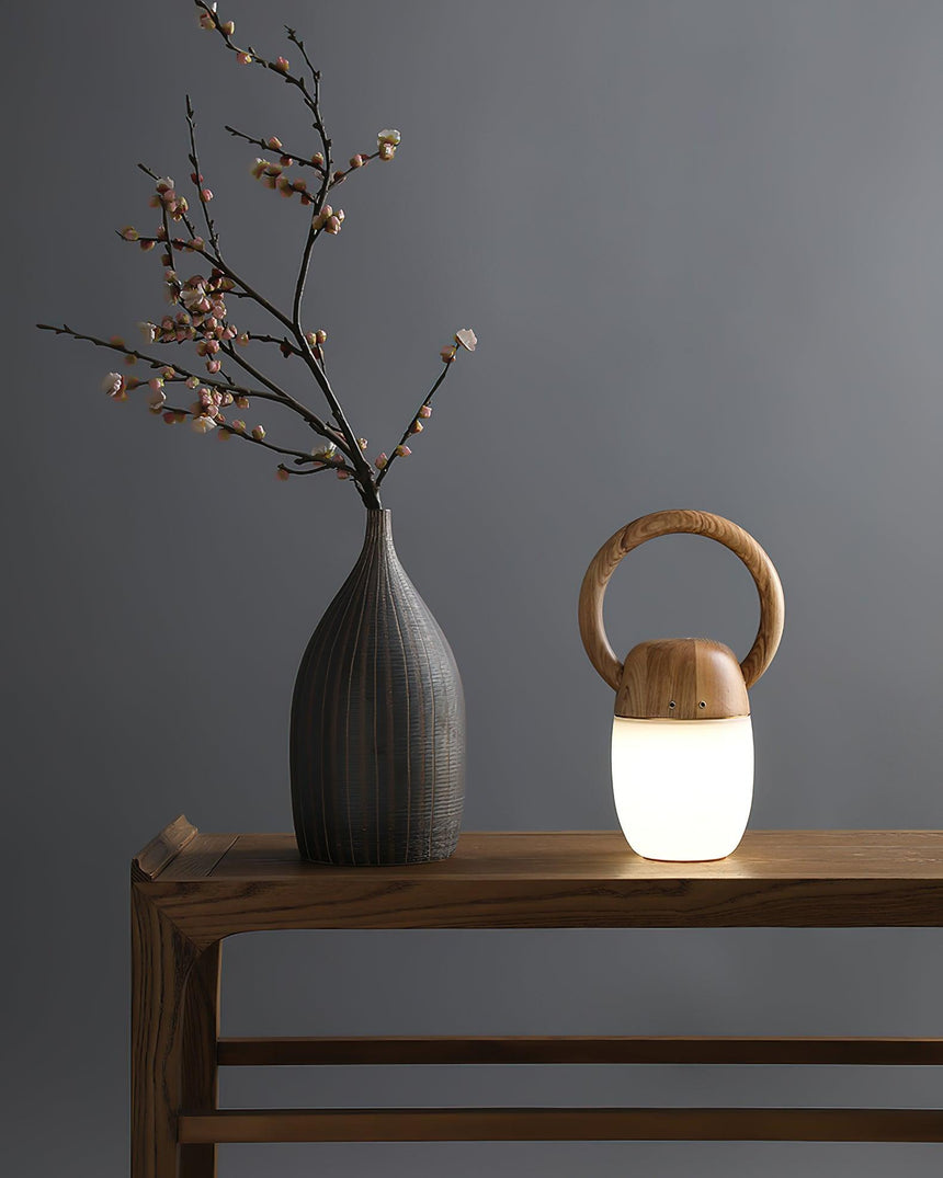 Dimmable bedside lamp unlit on a wooden console beside a stone vase