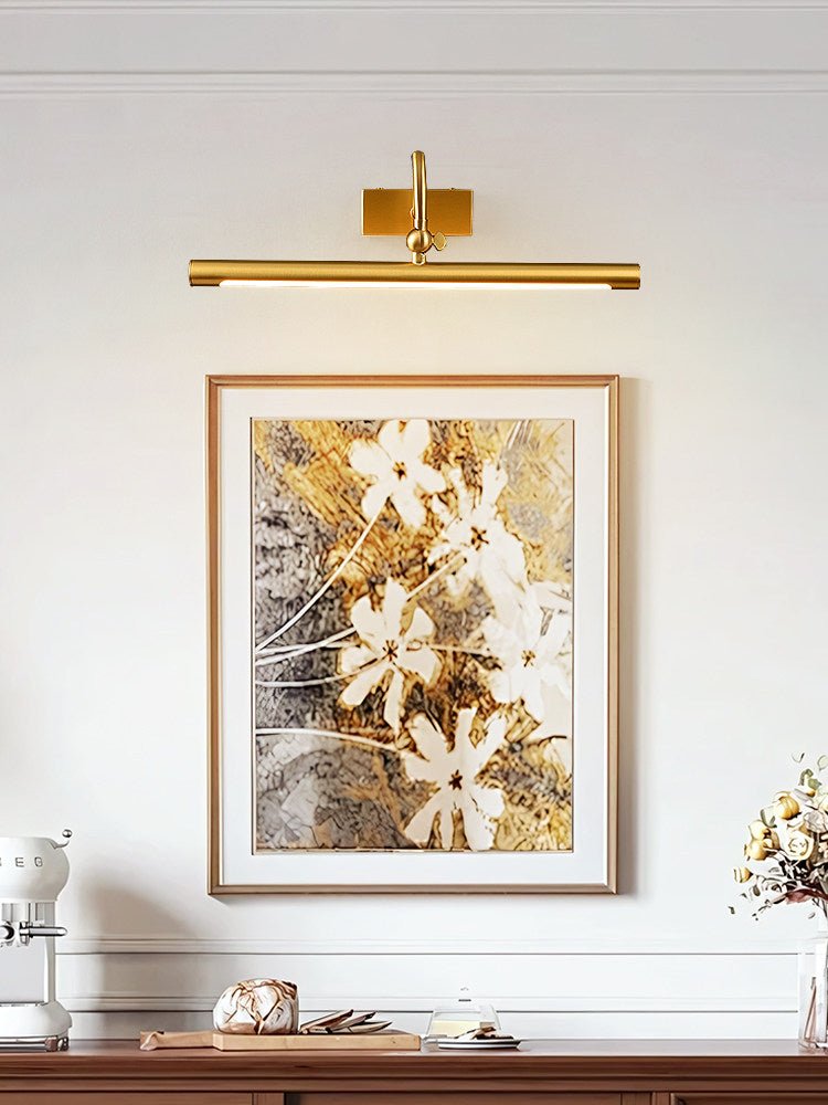 Brass bar lit over a framed floral canvas above a console with white objects