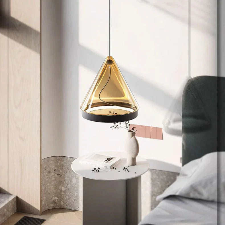 A cone pendant lit beside a bed above a round stone side table