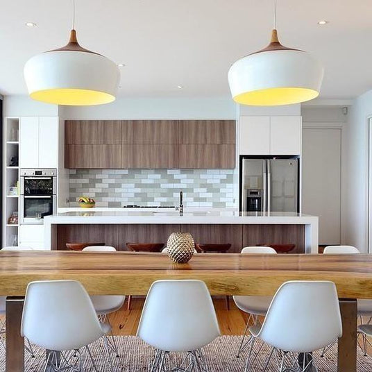 White domes lit above a kitchen counter with stools