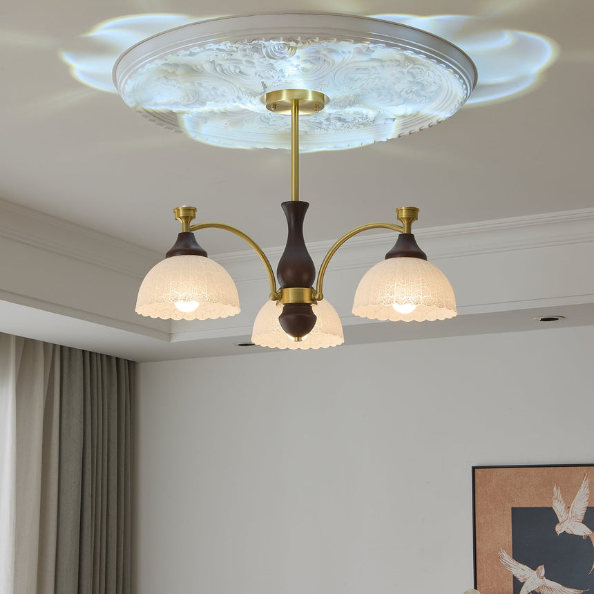 The fitting lit beside a long curtain above a wood chest of drawers