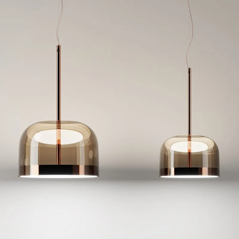 Dome pendant light in tinted glass hung in a row above a counter