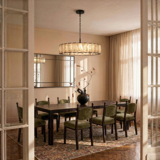A lit stone drum above a dining table set with green chairs