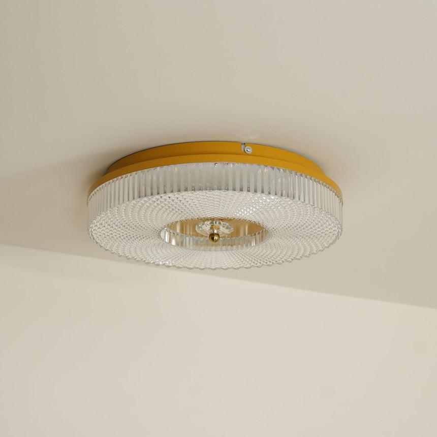 Ribbed drum ceiling light with a brass rim against a plain wall
