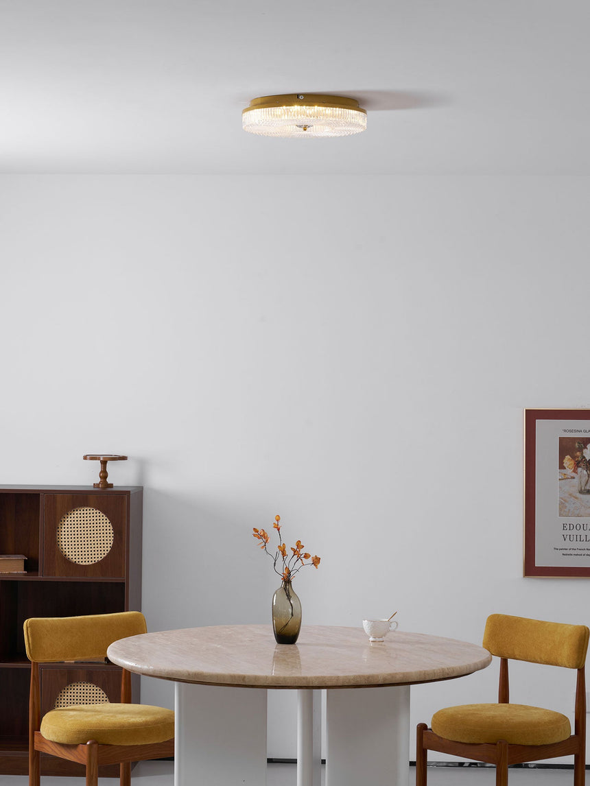 Ribbed drum ceiling light above a round dining table with yellow chairs