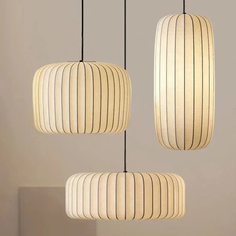 Pair of ribbed silk shades hung at different heights against a pale wall