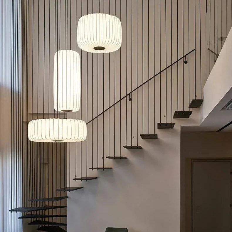 Ribbed silk drums hung in a line down a pale stairwell
