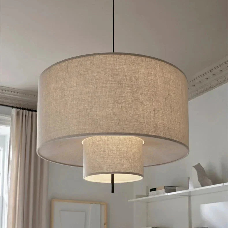 Close view of the woven oatmeal fabric and the dark rim of the drum shade