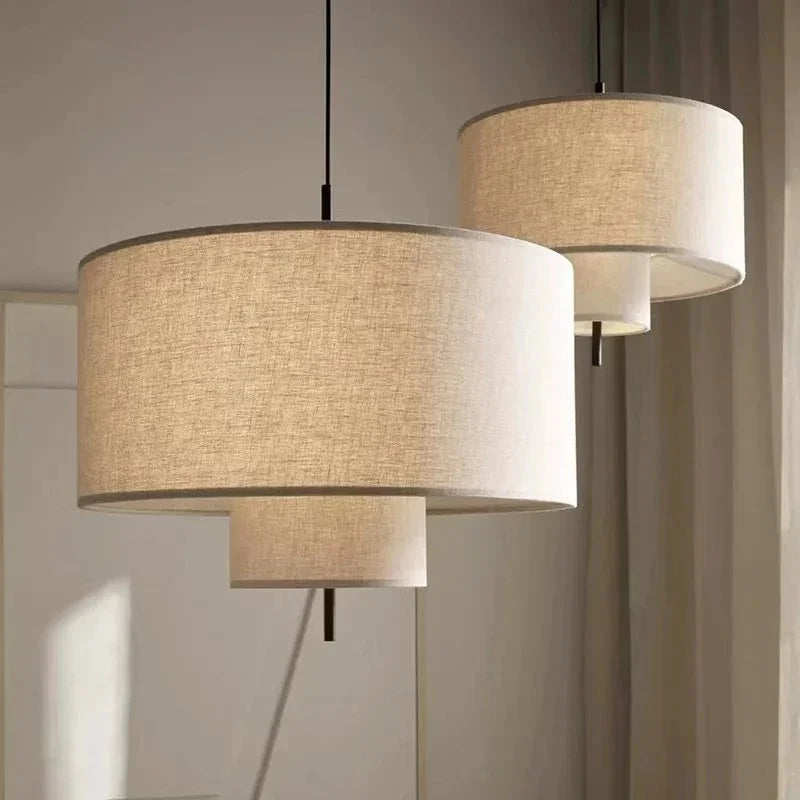 Drum shade pendant light in woven fabric, two hung at different heights