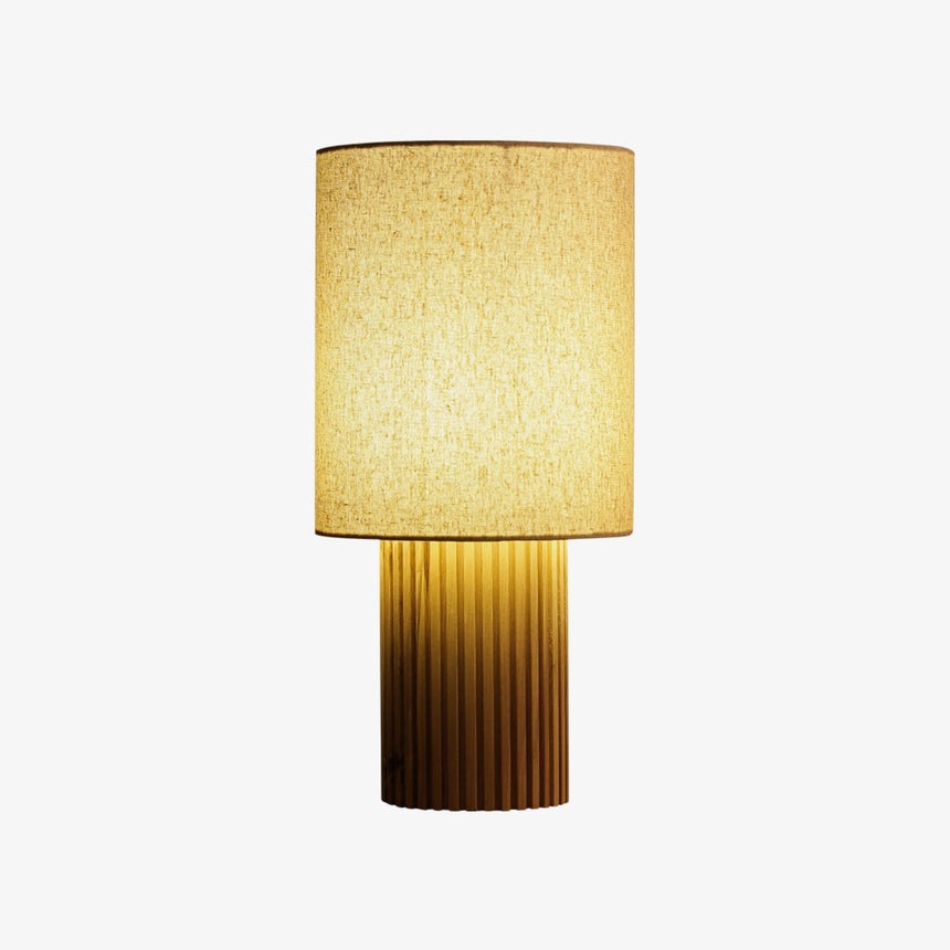 Natural wood entryway table lamp lit and seen from the front, plain background