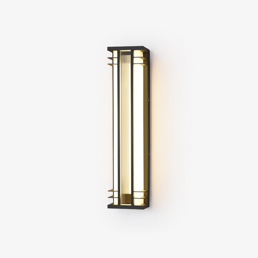 Black box outdoor wall light with gold tone trim and a ribbed acrylic panel, lit warm