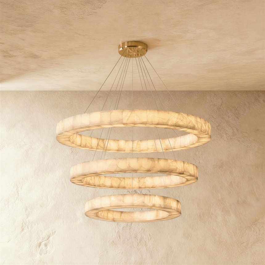 Three stacked alabaster rings lit on thin cables under a brass plate