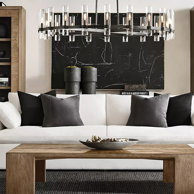 The black ring lit above a white sofa with cushions and a low wooden table