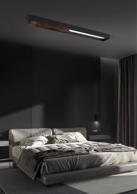 Bar mounted flat above a bed with rumpled bedding in a dark bedroom