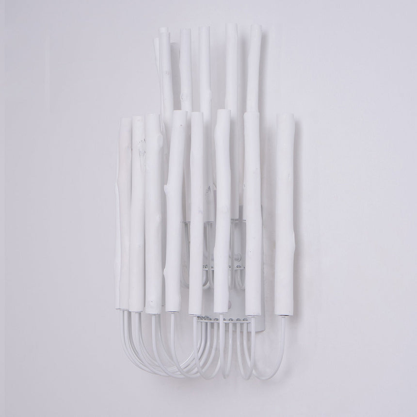 Cluster of white wood rods unlit, the looped frame visible underneath