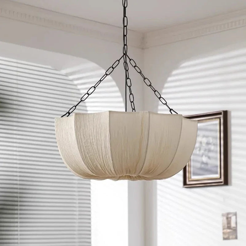 Two gathered fabric shades hung at different heights by a window