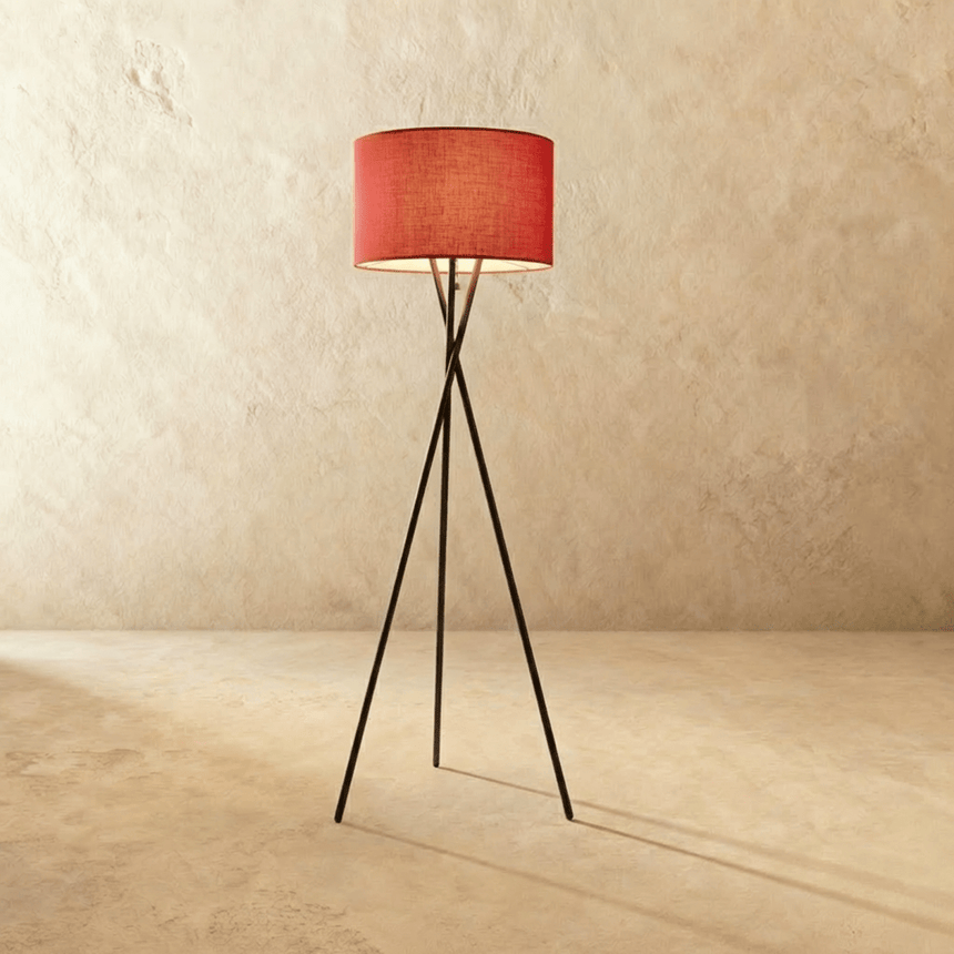 The crossed black tripod with a red fabric drum shade at the top