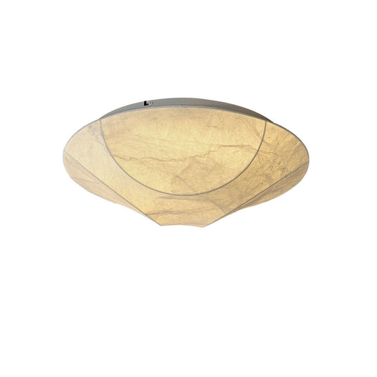 Round silk ceiling light seen at an angle against a plain backdrop