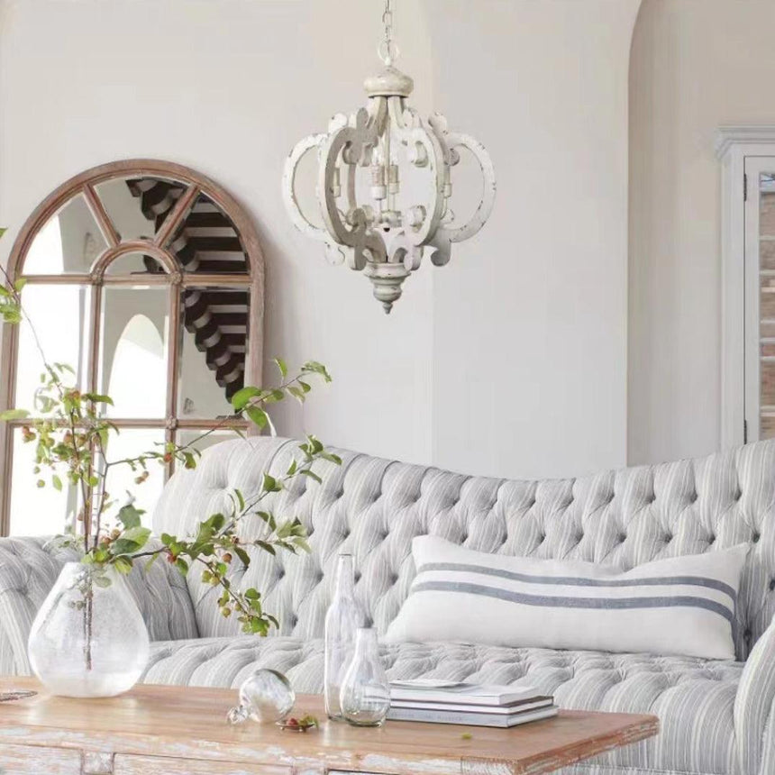 The fitting lit above a tufted sofa with an arched mirror behind
