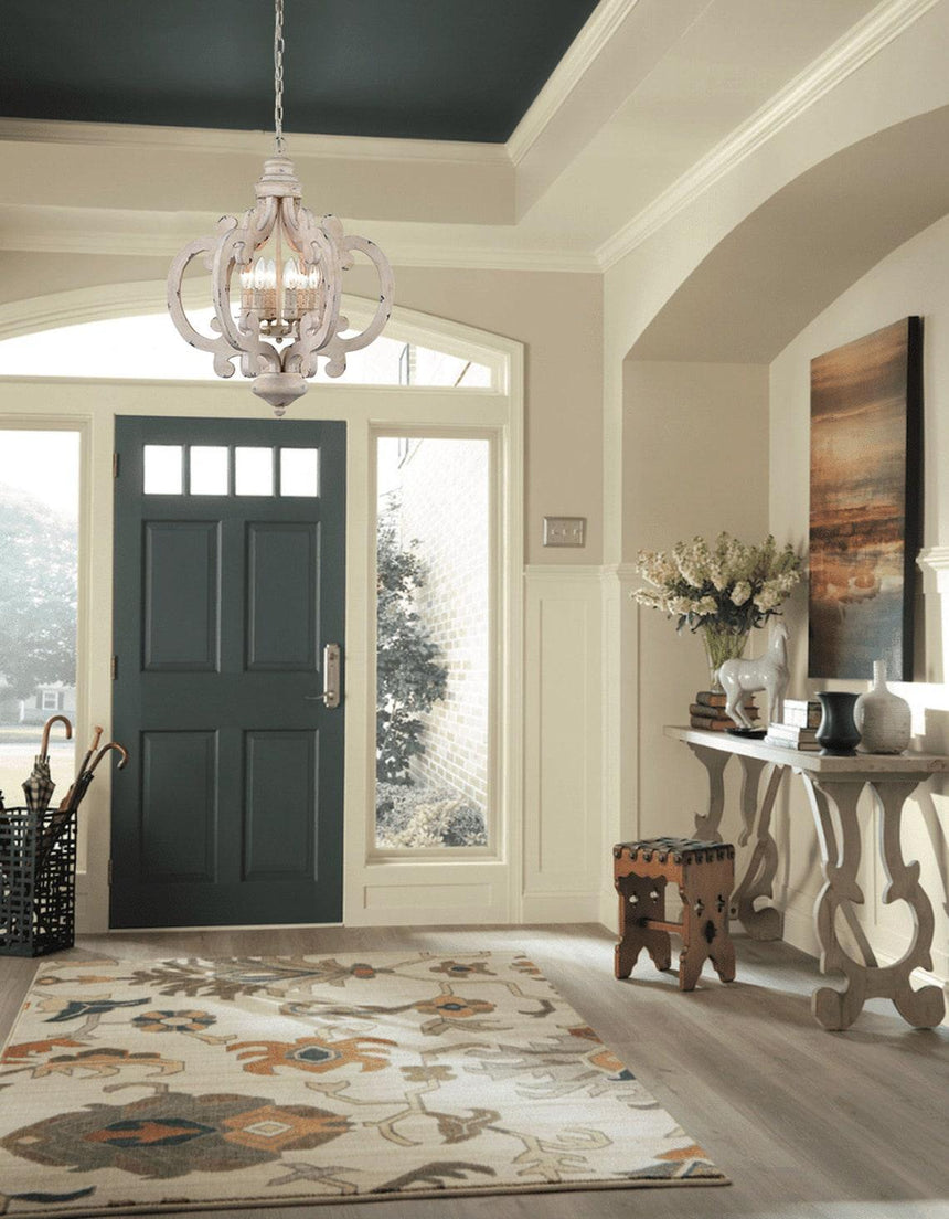 Chandelier lit in an entry hall above a console and a front door
