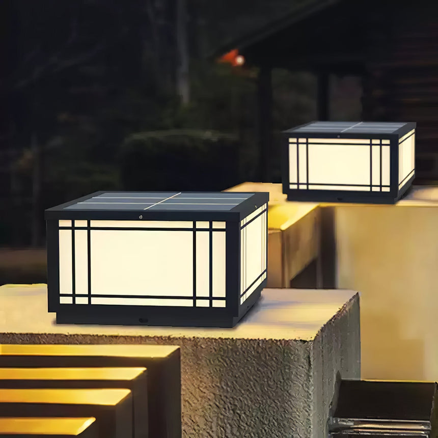 Two lit cube lanterns on pillars beside pale steps at nightfall