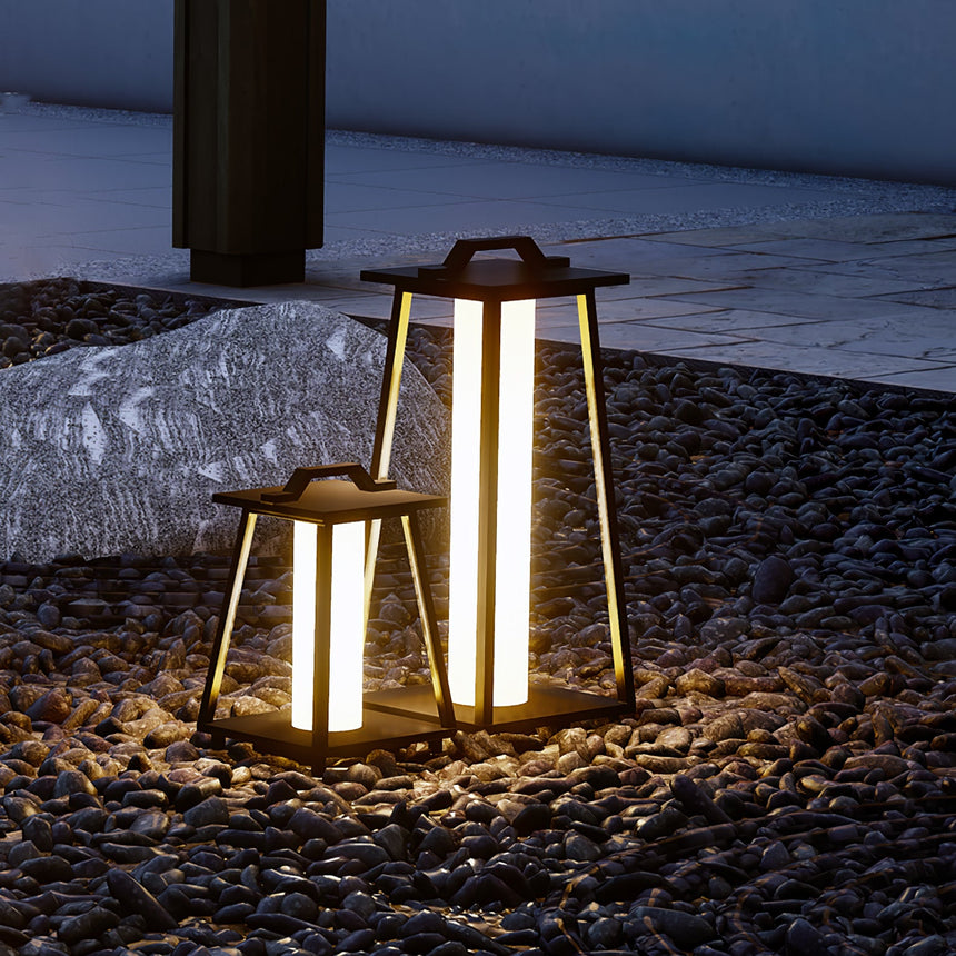 Two lit on dark gravel beside a pale rock in a planted border