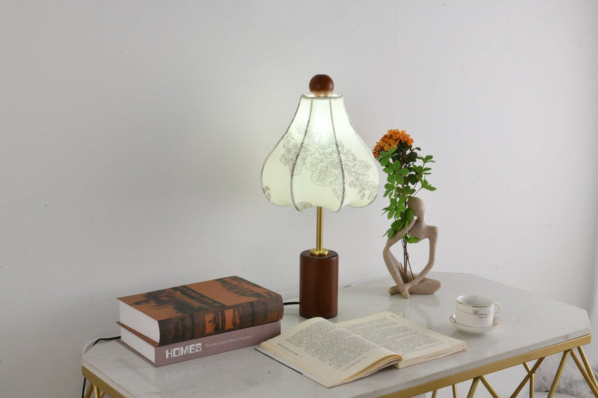 Parasol shade lamp lit with a cooler bulb on a pale desk
