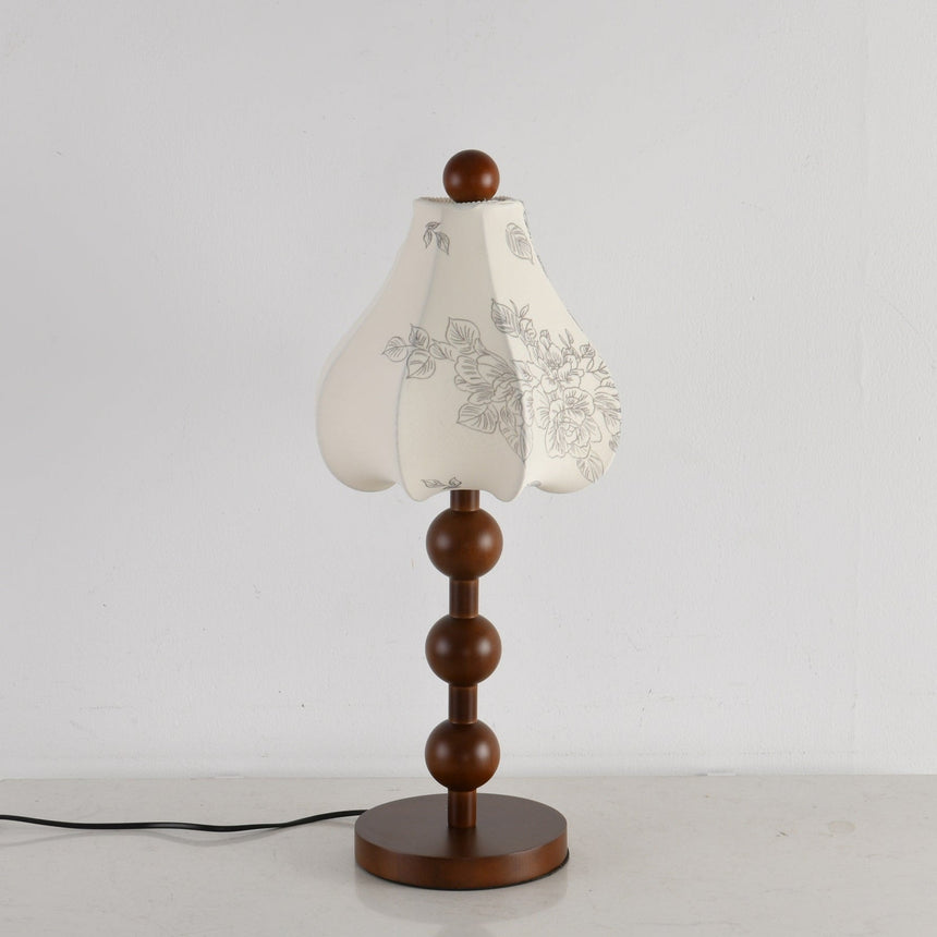 Walnut floral table lamp unlit, the printed pattern visible on the petals