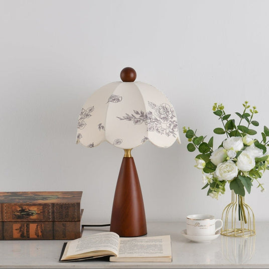 The botanical print and scalloped edge of the shade seen unlit