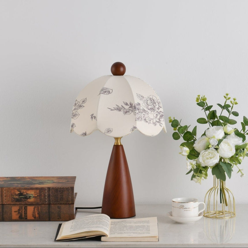 The botanical print and scalloped edge of the shade seen unlit