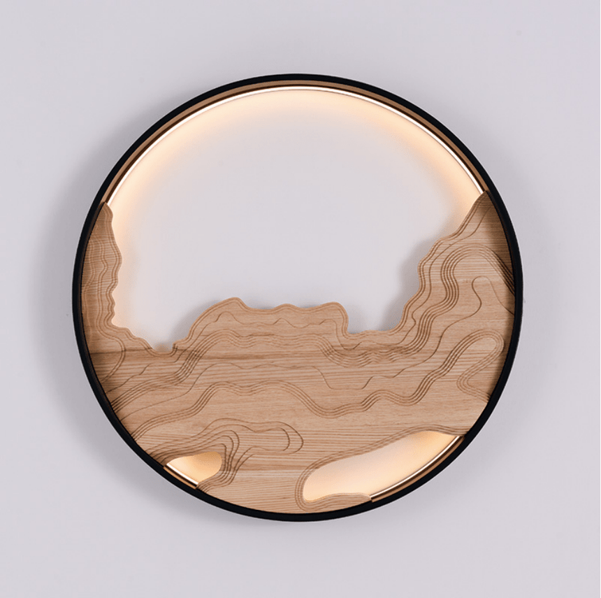 Carved wood contours lit from above and below inside a slim black ring