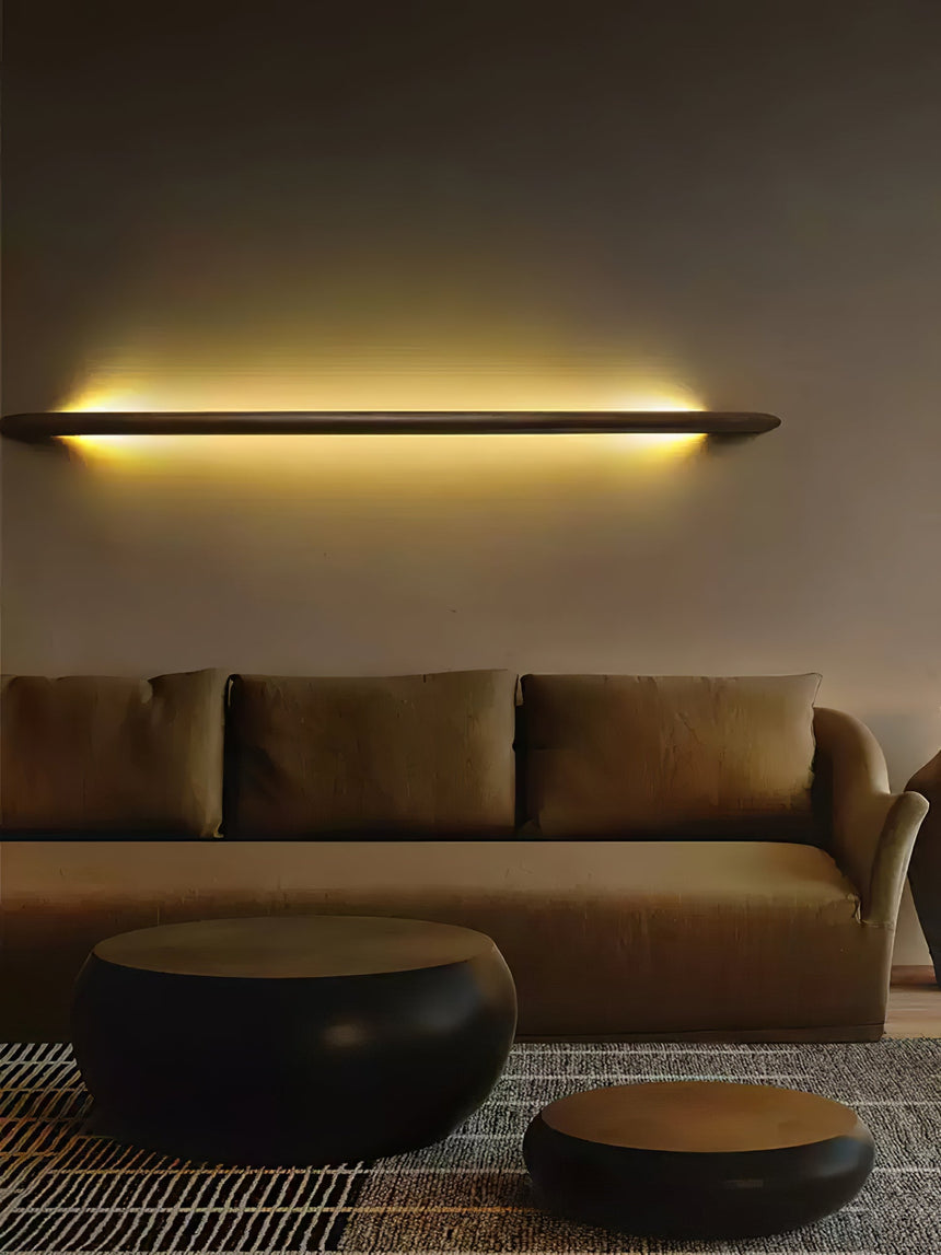 Lit rod above a wide sofa seen from across a plain living room
