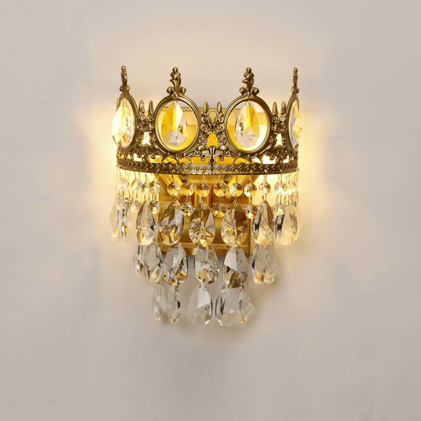 The crown lamp lit warm, the crystal drops glowing below the medallions