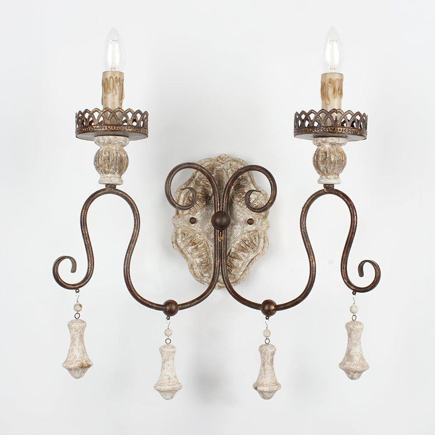 The turned wood drops hanging under each arm below the carved backplate