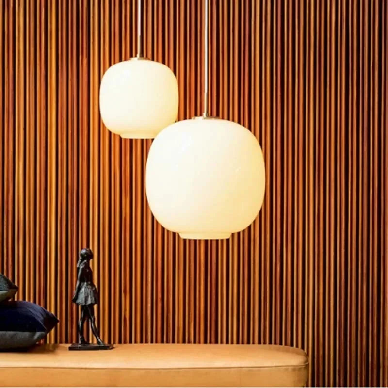 Two frosted globes lit against a slatted wood wall above a console