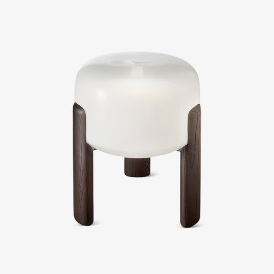 Frosted glass table lamp seen from the front on a plain pale ground