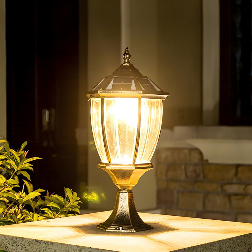 Warm light filling the lantern on a pillar beside a house wall