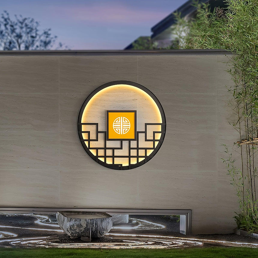 The light on a long courtyard wall above a pebble bed, bamboo to one side