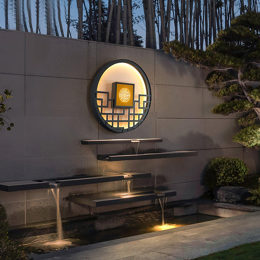 The light above a stepped stone fountain and a clipped pine in a walled garden