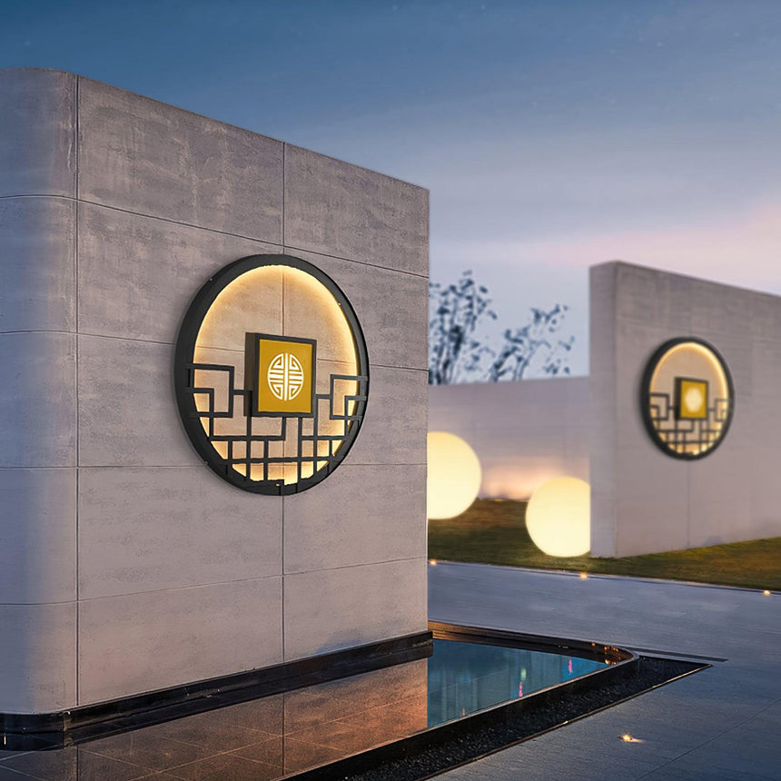 Two round lights on freestanding walls beside a reflecting pool at dusk