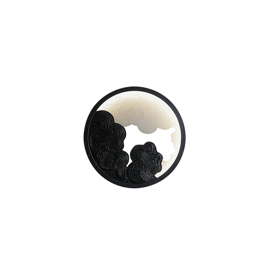 The black relief version, the lit disc bright behind the dark layers