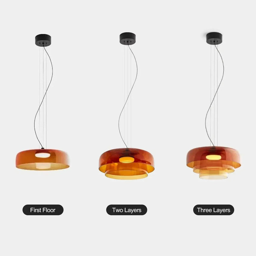 Three orange stacked glass shades hung in a row