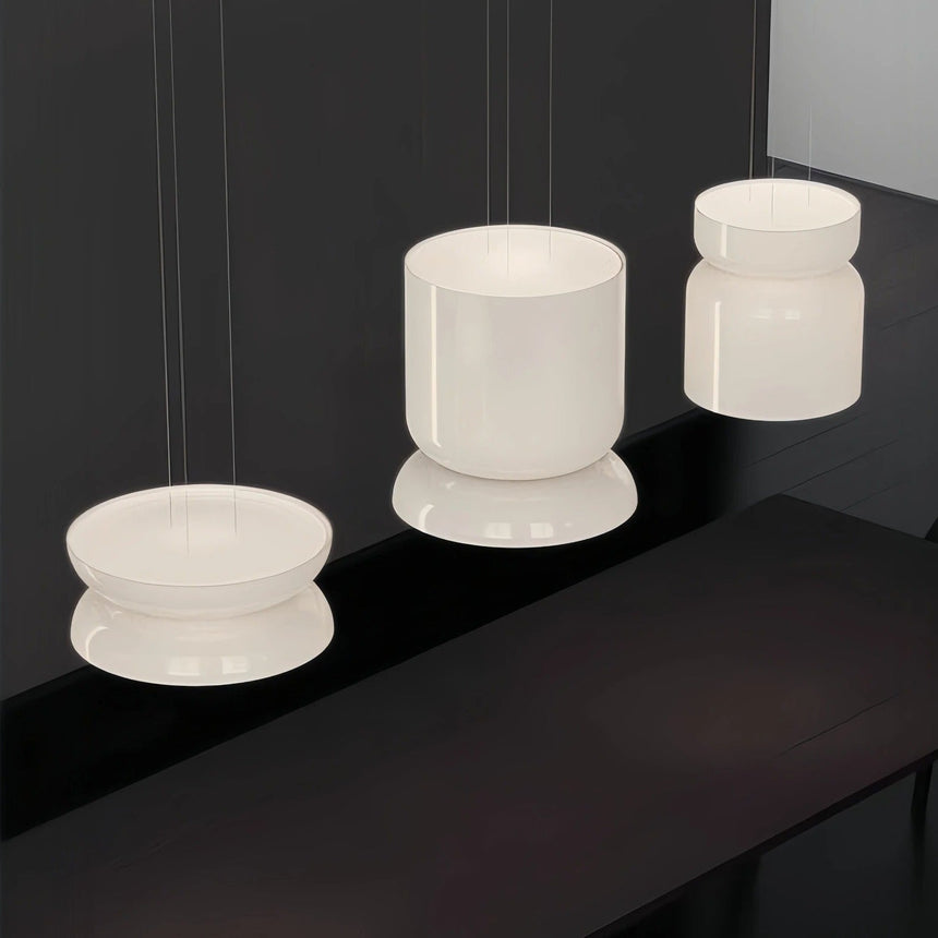Group of jade glass shades lit together above a dark surface