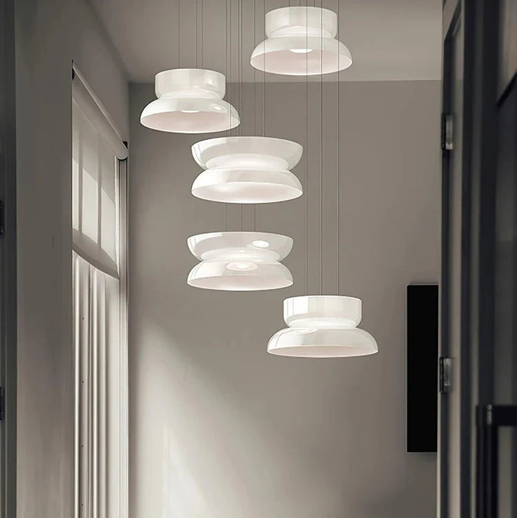 Several jade glass shades hung at staggered heights beside a tall window