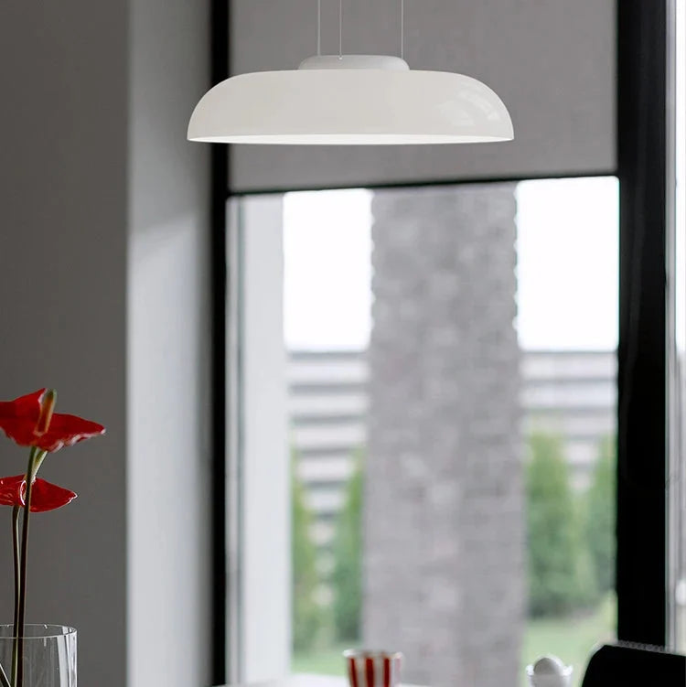 Single white glass shade hung in front of a bright window