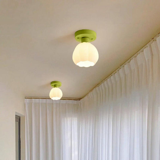 Two flower shade ceiling lights lit along a hallway ceiling beside curtains